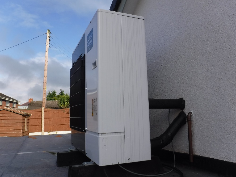 Heat pump installed on garage roof outside AECB Retrofit Standard bungalow in Wrexham
