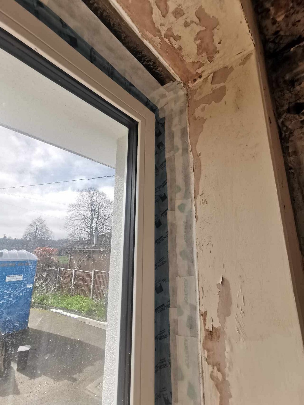 Airtight tape from window frame to reveal before plastering, AECB Retrofit Standard bungalow, Wrexham